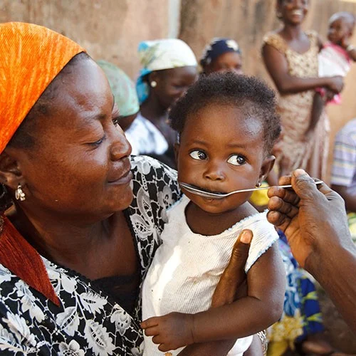 Mädchen in Ghana trinkt Flüssigkeit mit Rehydrationssalzen