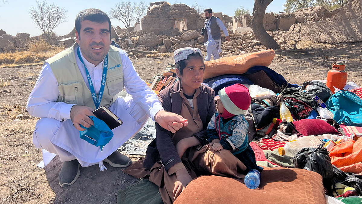 Afghanische Kinder sitzen erschöpft in den wenigen Habseligkeiten, die sie aus ihrem zerstörten Zuhause retten konnten.