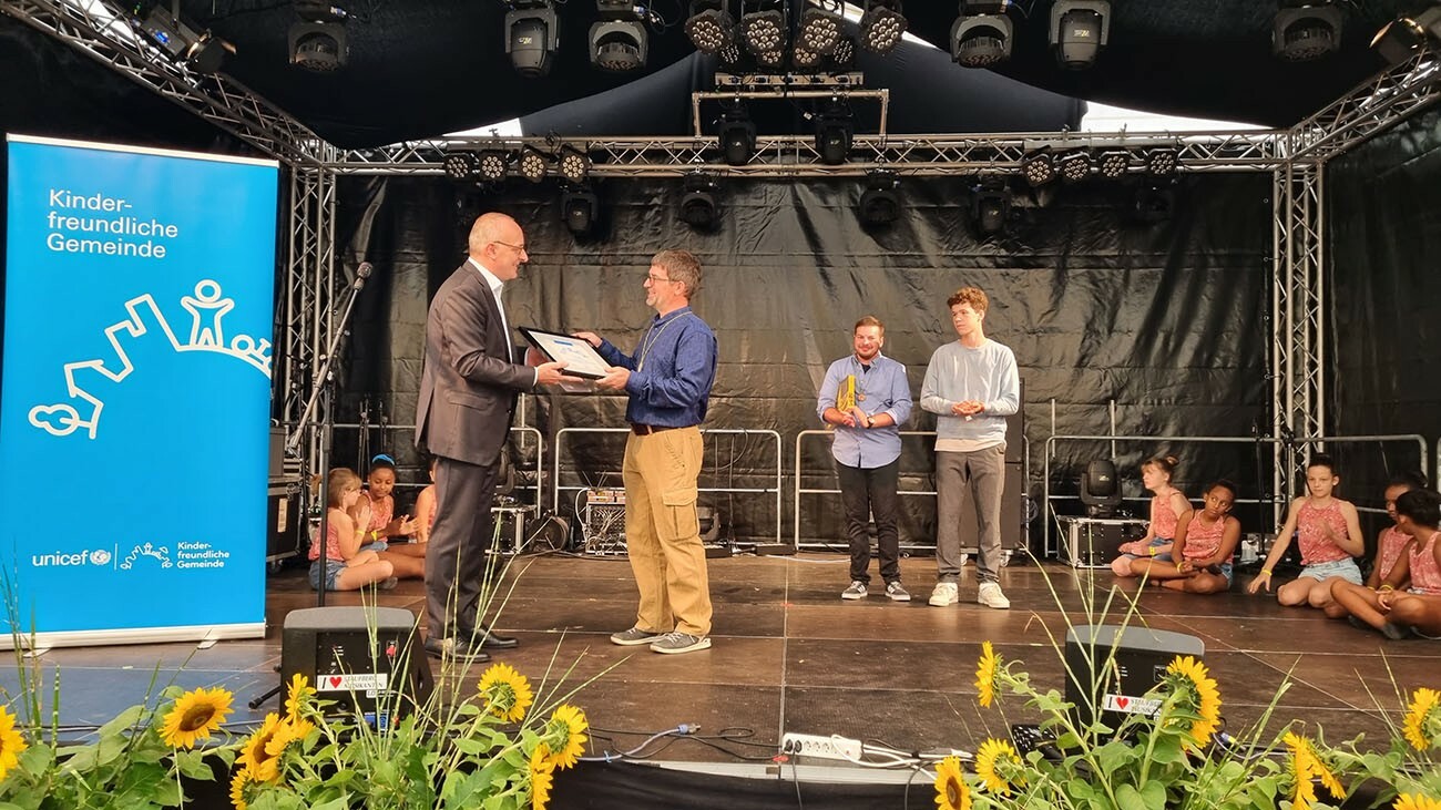 Cyrill Tait, stv. Geschäftsleiter von UNICEF übergibt Gemeindepräsident Stefan Gschwind die Auszeichnung.