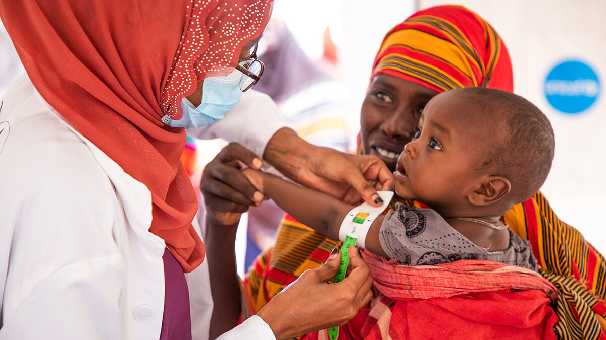 Un bambino riceve la vaccinazione tra le braccia della madre.