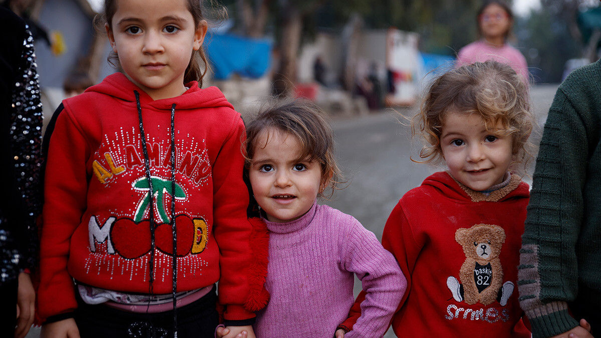 Drei Mädchen halten sich in einer Notunterkunft in der Türkei an den Händen.