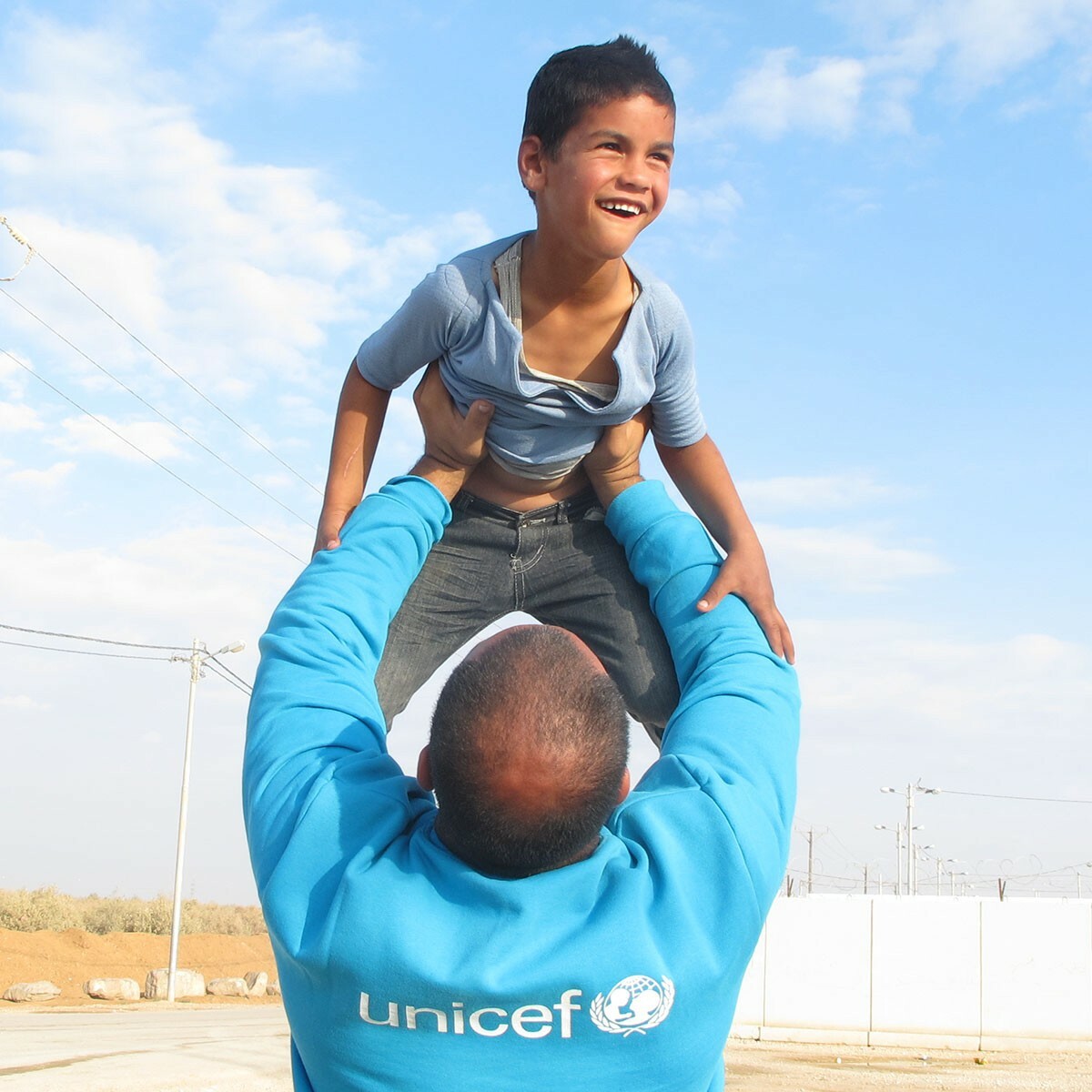 Junge auf Armen von UNICEF-Mitarbeiter