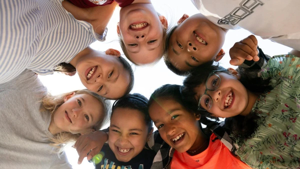 Kinder lachen in die Kamera