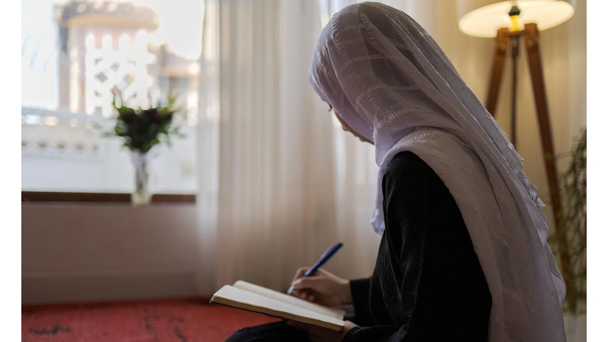 Suraya, 18 ans, écrit chez elle après avoir été privée d’accès à l’école – tout en rêvant toujours de devenir médecin.