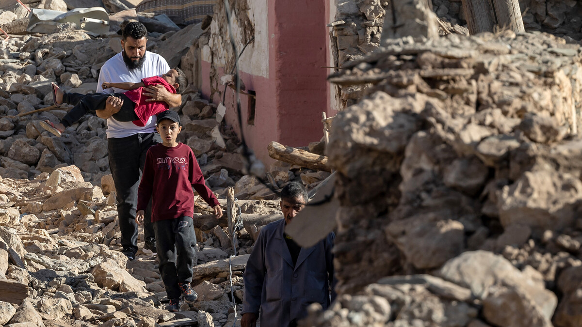 Ein Mann trägt ein Mädchen durch die Trümmer einer Wohngegend im marokkanischen Bergdorf Tafeghaghte, südwestlich der Stadt Marrakesch. 