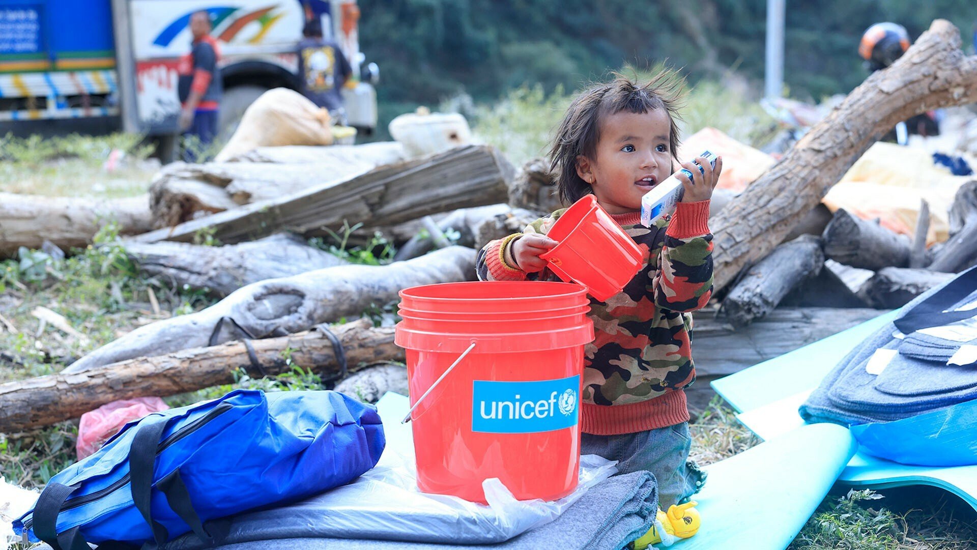 Kind spielt mit UNICEF-Hilfsgütern nach Nothilfe Erdbeben Nepal