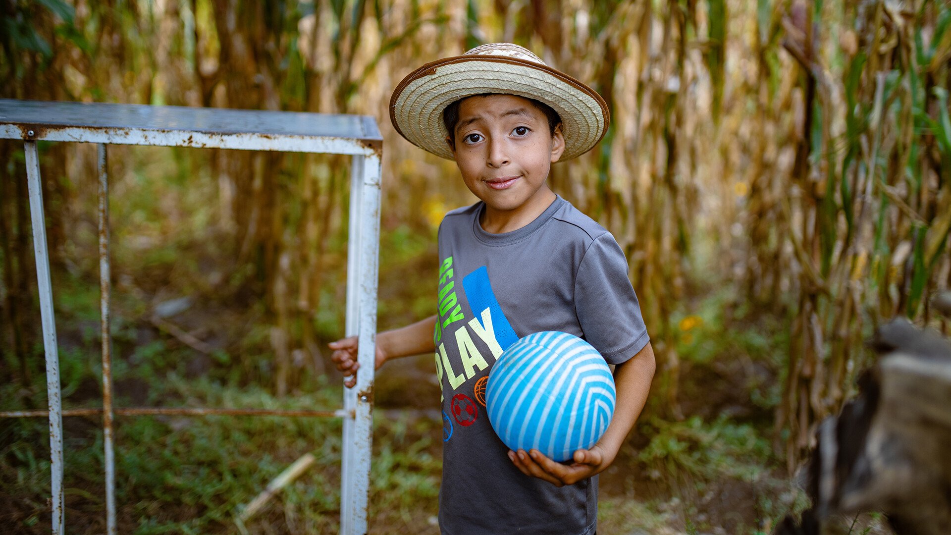 Ein Junge spielt in einem Feld in Guatemala mit seinem Fussball.
