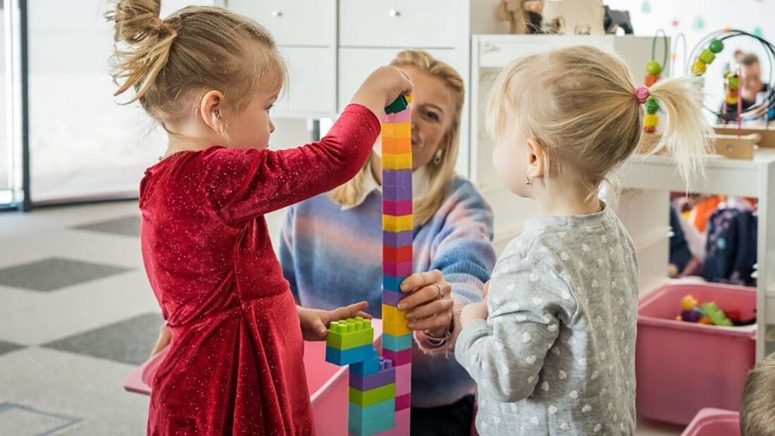 Deux petites filles construisent une tour avec des briques Lego.
