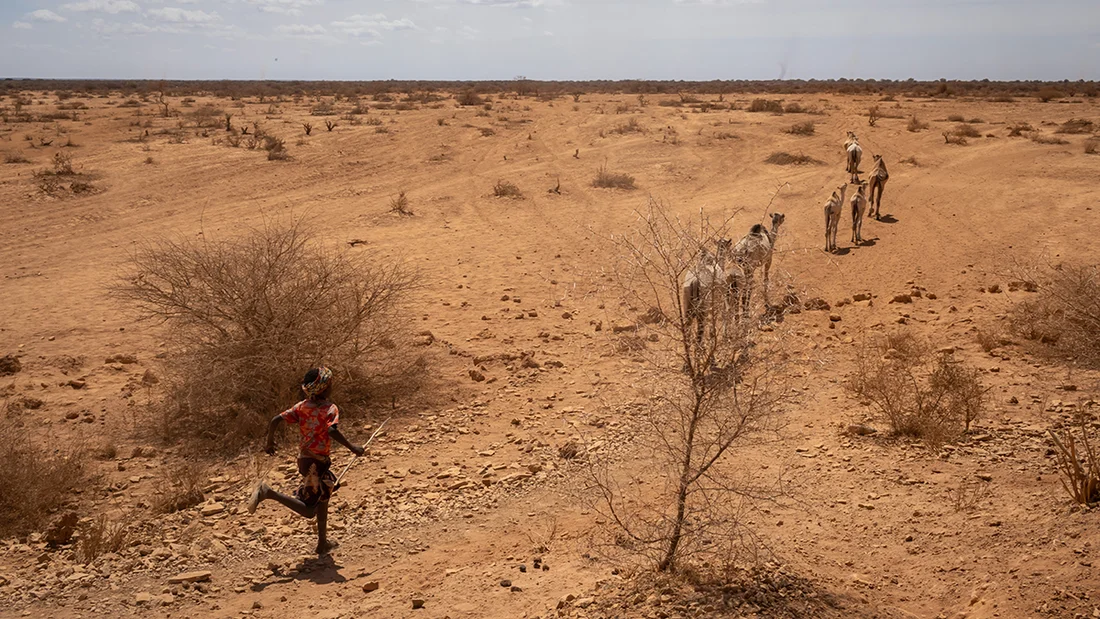 Child runs across dry land.