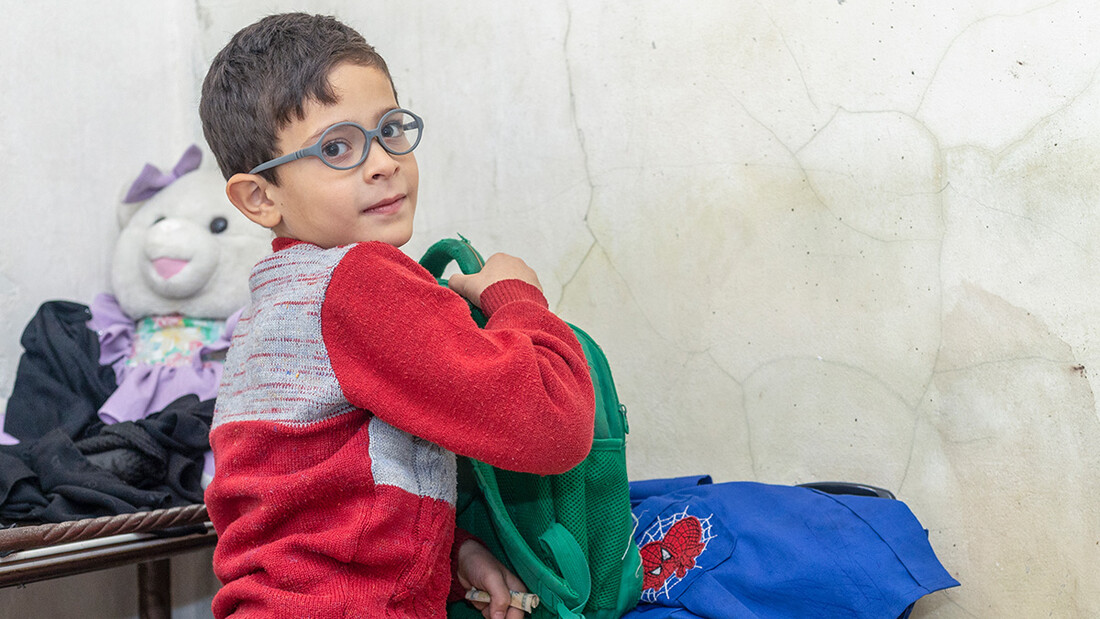 Radwan (9 anni) si appresta a fare i compiti a casa nel distretto Tal Az-Zarazir ad Aleppo, Siria. Desidererebbe che la madre potesse comprargli una lavagna da usare quando studia.