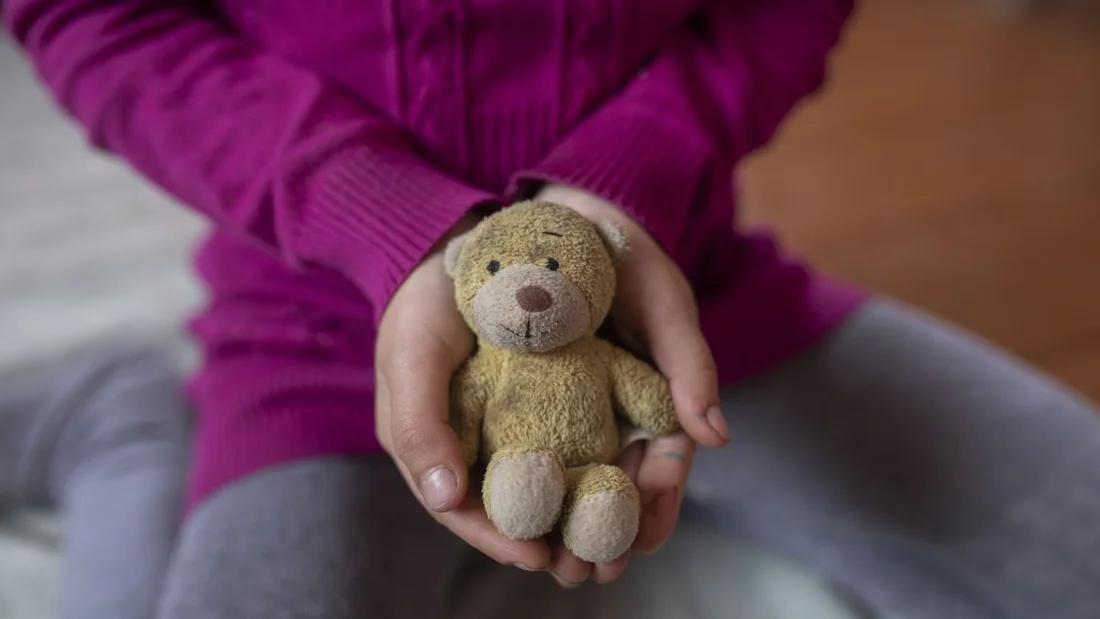 Una bambina di 8 anni dell'Ucraina tiene in braccio un orsacchiotto.