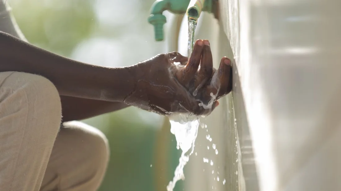 Una bambina di 10 anni si lava le mani con acqua pulita e sapone in uno spazio didattico sicuro in Sudan.