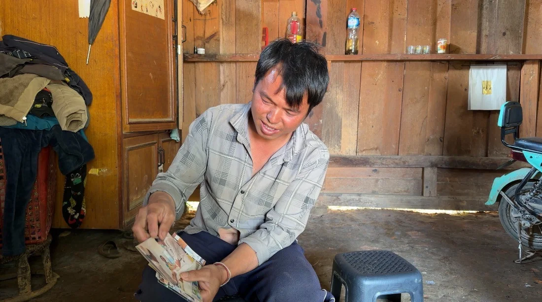 Laos, UXO, der Vater von Kayeng zeigt alte Fotos nach dem Unfall