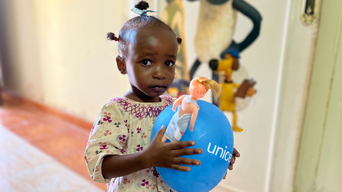 A little girl holding a UNICEF balloon