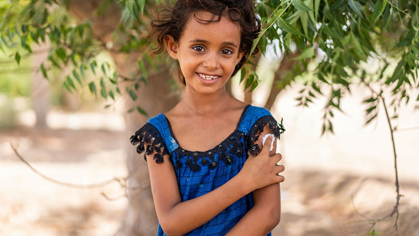 Im Gouvernement Aden, Jemen, hält die 7-jährige Hind Ali Nasser ihren Arm, nachdem sie geimpft wurde.