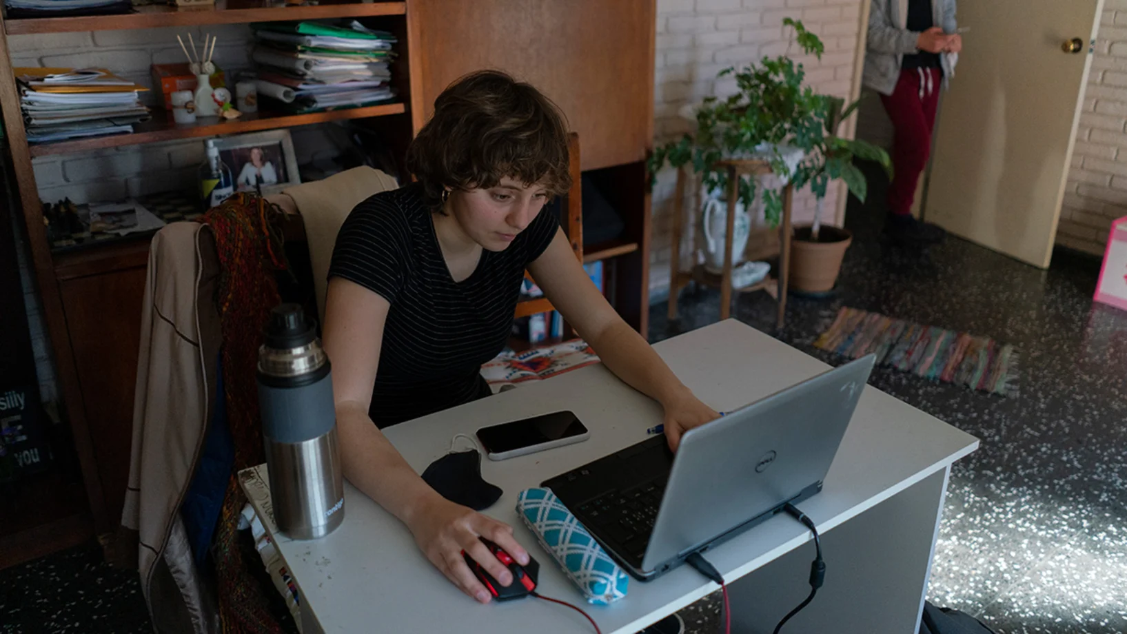 Ein Mädchen sitzt an ihrem Schreibtisch vor ihrem Laptop.