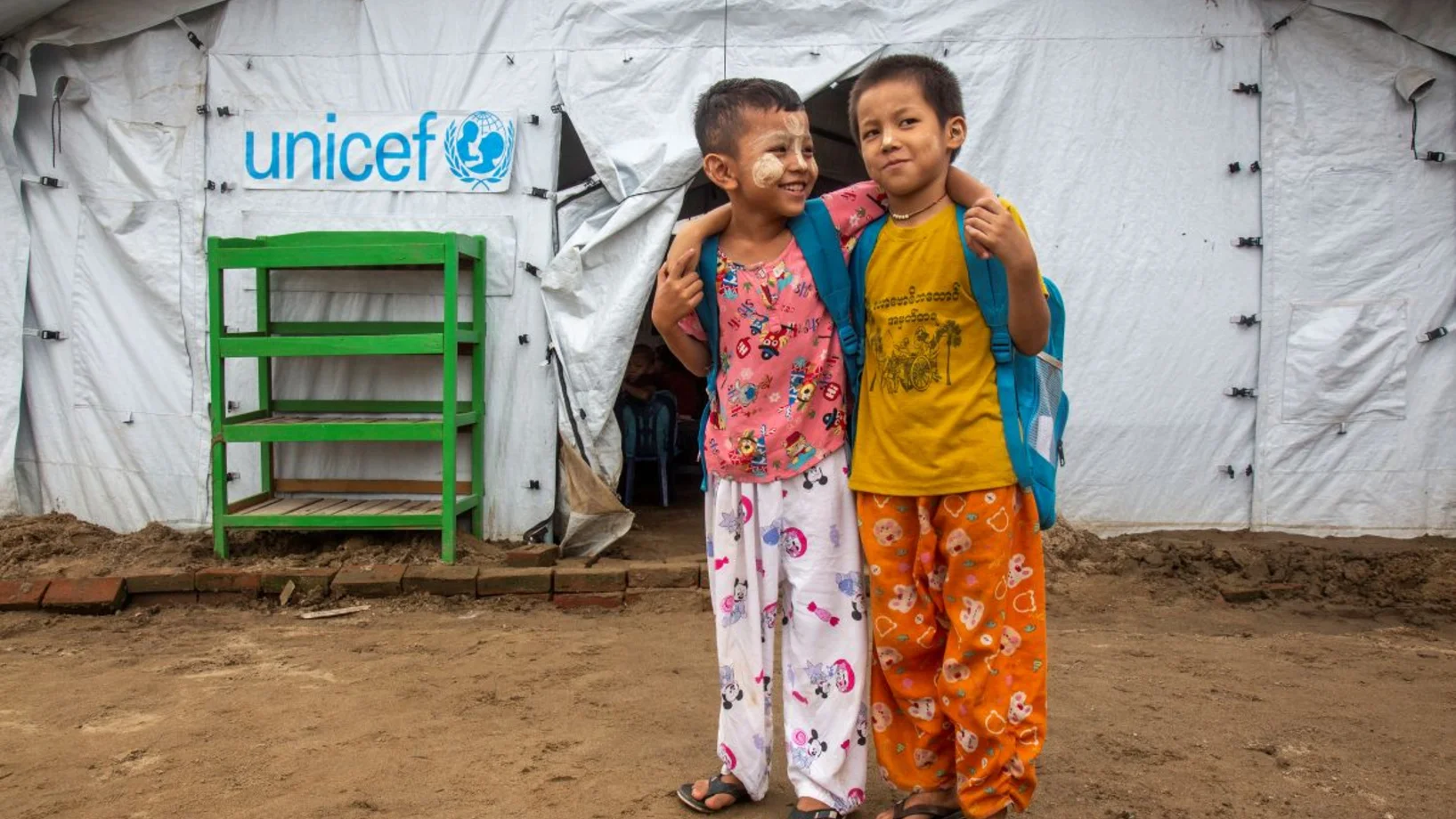 Zwei Kinder vor einem UNICEF Zelt