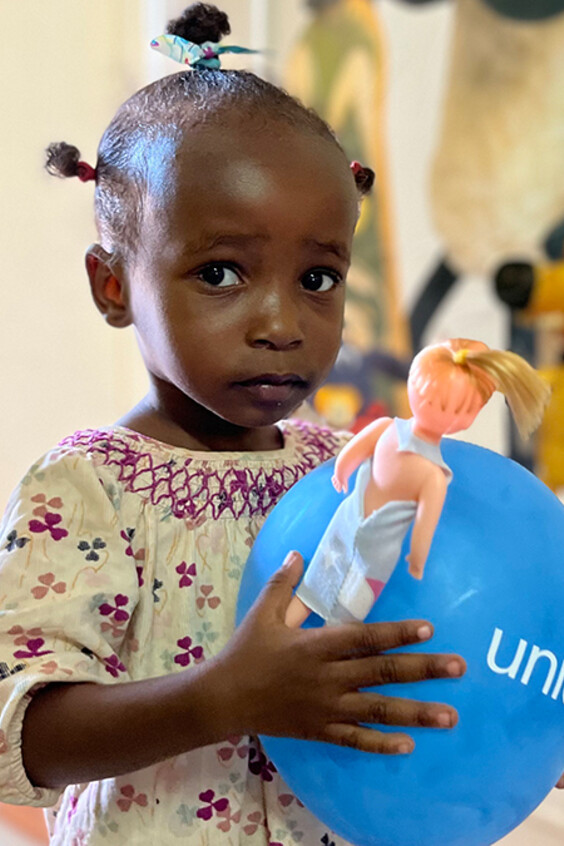 A little girl holding a UNICEF balloon