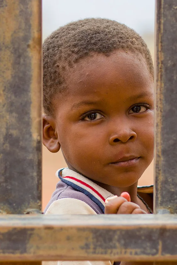 A little boy looks into the camera.