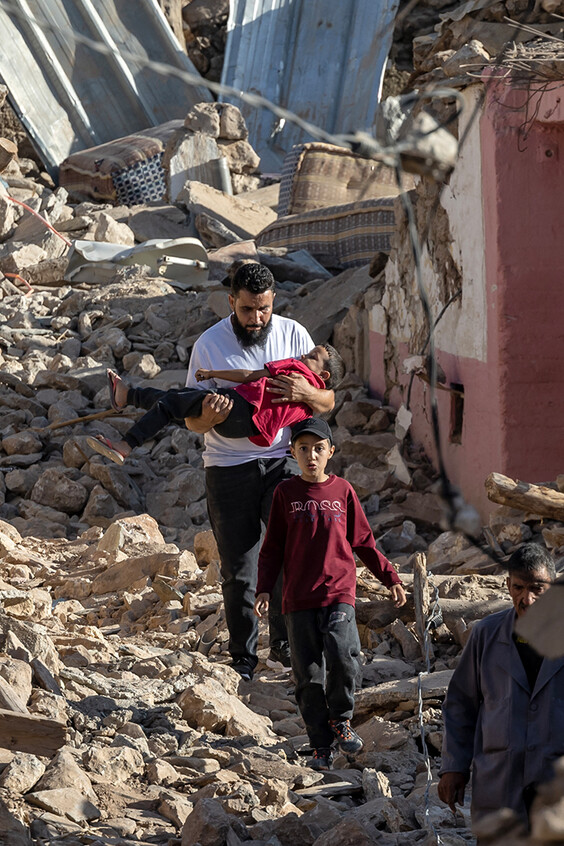 Ein Mann trägt ein Mädchen durch die Trümmer einer Wohngegend im marokkanischen Bergdorf Tafeghaghte, südwestlich der Stadt Marrakesch.