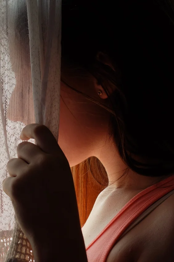 Junge Frau hinter Vorhang