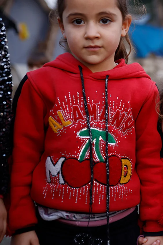 Drei Mädchen halten sich in einer Notunterkunft in der Türkei an den Händen.