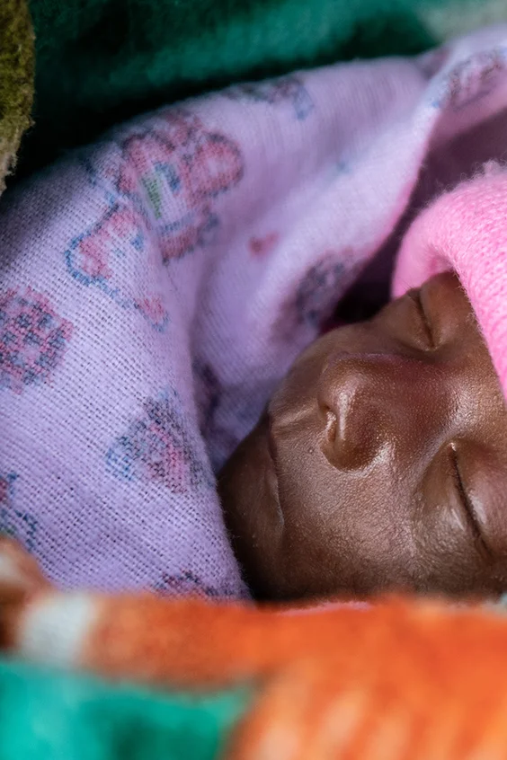 Ein kleines Baby ist warm eingewickelt.
