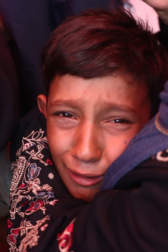Ein kleiner Junge in Gaza steht zwischen Frauen und weint bitterlich.