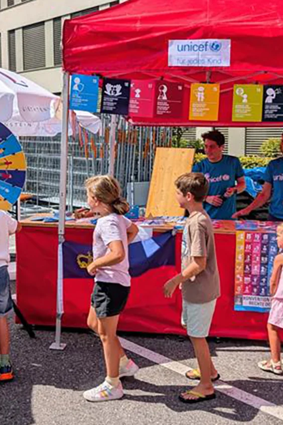 Kinder sind am UNICEF Stand und spielen.