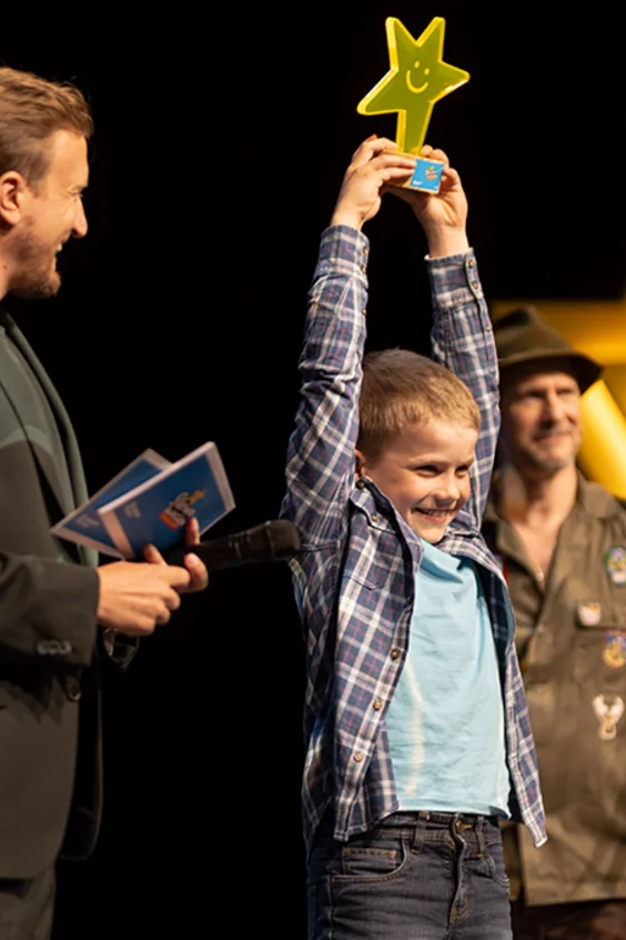 Lukas Schneider aus Freienwil (AG), Gewinner des UNICEF Sternenwochen-Awards 2025 in der Kategorie Einzelkinder, hält stolz seinen Award in die Höhe.